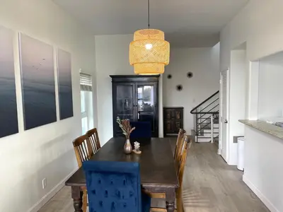 a dining room with a wooden table and blue chairs at Luxe 2-BR with King suite, rooftop, steps from beach in Los Angeles
