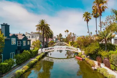 a bridge over a river in a city with palm trees at King Oasis - steps to beach with garden patio! in Los Angeles