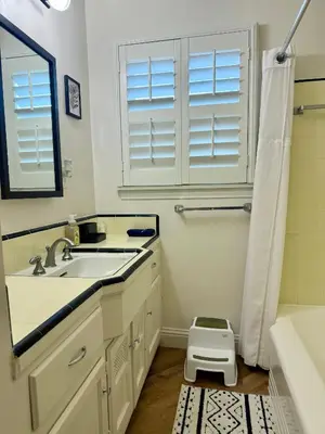 a white bathroom with a sink and a shower at Historic, Family-Friendly Home in Downtown in Bakersfield