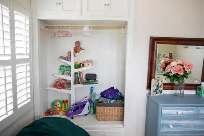 a childs bedroom with white walls and white shelves at Historic, Family-Friendly Home in Downtown in Bakersfield