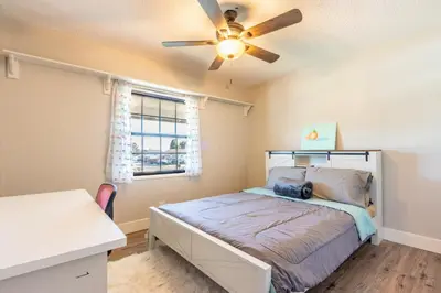 a bedroom with a bed and a ceiling fan at Spacious 4BR Retreat near Disneyland & Beaches in Placentia