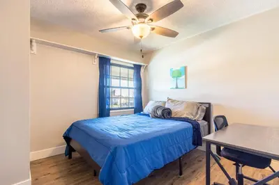 a bedroom with a bed and a ceiling fan at Spacious 4BR Retreat near Disneyland & Beaches in Placentia