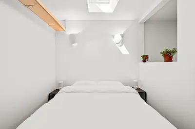 a bedroom with white walls and a white bed at Scenic Retreat with Deck & Stunning Views in LA in Glendale