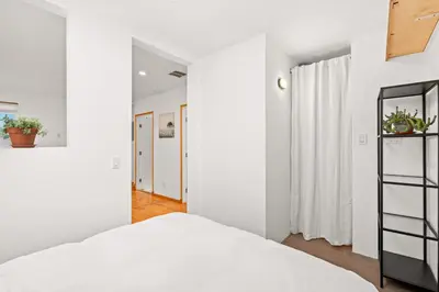 a bedroom with white walls and a white bed at Scenic Retreat with Deck & Stunning Views in LA in Glendale