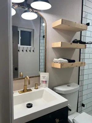 a bathroom with a sink and a mirror and a toilet at Luxury Home LA Big Bear & LV 5 Mins to Mall in Victorville