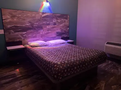a bedroom with a bed with a large headboard at Bob's Motel in Commerce