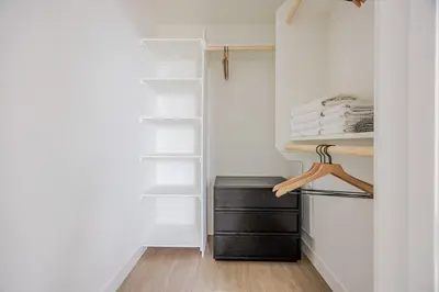 a walk in closet with white walls and wooden shelves at Blueground San Pedro AC balcony nr USS Iowa LAX-1301 in Los Angeles