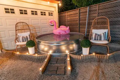 a pink flamingo sitting on a patio with two chairs at LA Karaoke Fire Pit Ping-Pong Cowboy Pool in Glendale