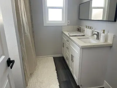 a white bathroom with a sink and a mirror at Vacation-Poppy Fields, Antelope Valley & Aerospace in Lancaster