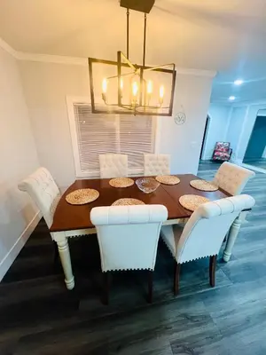 a dining room table with white chairs and a chandelier at Vacation-Poppy Fields, Antelope Valley & Aerospace in Lancaster