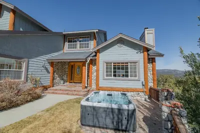 a house with a hot tub in the front yard at Valley View Cabin in Big Bear Lake