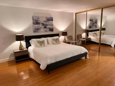 a bedroom with a large bed and a mirror at Coastal haven retreat in Los Angeles