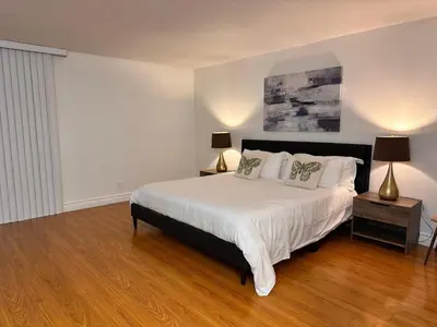 a bedroom with a large white bed with two lamps at Coastal haven retreat in Los Angeles