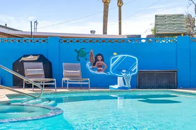 a pool at a resort with a blue wall at Mickeys House by OC Adventure Homes in Anaheim