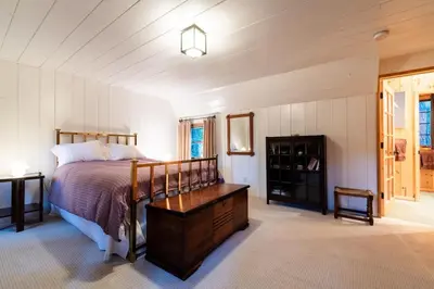 a bedroom with a bed and a wooden dresser at Contemporary Classic on a Private Mountain Lake in Lake Arrowhead