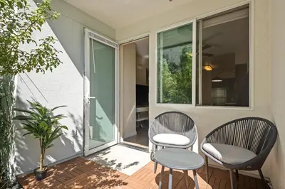 two chairs and a table on the porch of a house at Chic 1BR Retreat with Pool, Gym & Jacuzzi in Mid Wilshire & Miracle Mile in Los Angeles