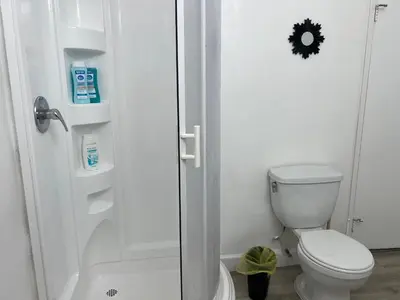 a white bathroom with a toilet and a shower at NoHo Cozy Cove in Burbank