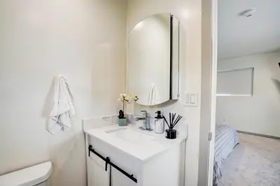 a white bathroom with a sink and a mirror at The Pacific Nest - 10min from LAX in Hawthorne