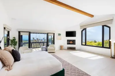 a bedroom with a large bed and a fireplace at Malibu Park by Stay Awhile Villas in Malibu