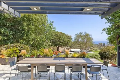 a patio with a wooden table and chairs at Malibu Park by Stay Awhile Villas in Malibu