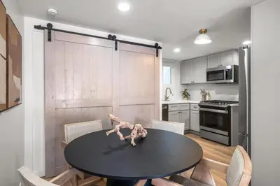 a kitchen with a black table and chairs in a room at The South Bay Retreat in Redondo Beach