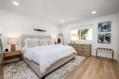 a white bedroom with a large bed and a window at The South Bay Retreat in Redondo Beach