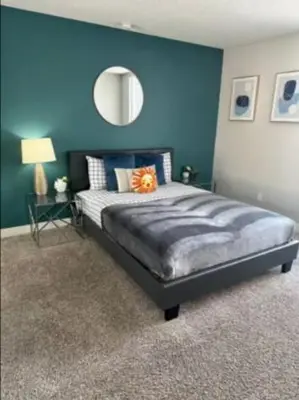 a bedroom with a large bed with a blue wall at 2-Bedroom Hollywood Apartment in Los Angeles