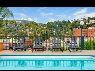 a group of chairs sitting next to a swimming pool at 2-Bedroom Hollywood Apartment in Los Angeles