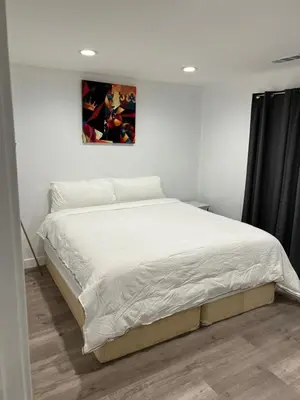 a bed in a bedroom with a picture on the wall at Private gated 1bed & 1bath amazing for 2 in Los Angeles near Universal studio & Hollywood in Van Nuys Airport