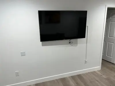 a flat screen tv hanging on a white wall at Private gated 1bed & 1bath amazing for 2 in Los Angeles near Universal studio & Hollywood in Van Nuys Airport