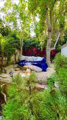 a bed in the middle of a garden with trees at Enchanting Gated Hollywood Hills Oasis with Tranquil Treet-Top Views, Outdoor Living Room and Patios, Magical Zen Garden, Plus Bonus Romantic Guest House and Free Garage in LA's Most Desirable Central Serene Area, Sleeps 8-10 in Los Angeles