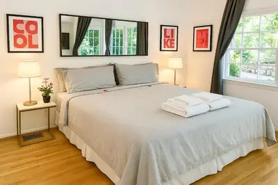 a bedroom with a bed with two towels on it at Enchanting Gated Hollywood Hills Oasis with Tranquil Treet-Top Views, Outdoor Living Room and Patios, Magical Zen Garden, Plus Bonus Romantic Guest House and Free Garage in LA's Most Desirable Central Serene Area, Sleeps 8-10 in Los Angeles
