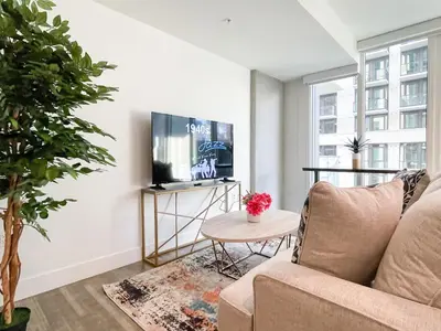 a living room with a couch and a tv at Suite Downtown Pool and Gym Access in Los Angeles