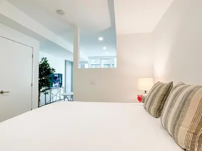 a bedroom with a white bed and a window at Suite Downtown Pool and Gym Access in Los Angeles