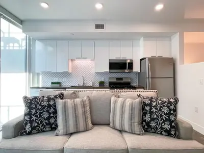 a living room with a couch and a kitchen at Suite Downtown Pool and Gym Access in Los Angeles