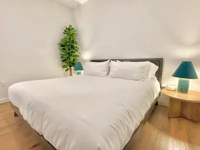 a white bed in a room with a potted plant at 3 Bedroom 2 Bath Westwood Condo in Los Angeles