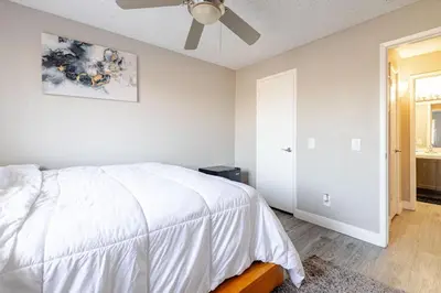 a bedroom with a white bed and a ceiling fan at The Chic Loft in Riverside