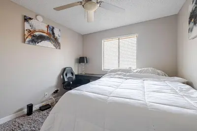 a bedroom with a white bed and a ceiling fan at The Chic Loft in Riverside