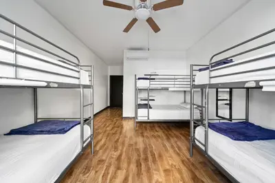 a room with three bunk beds with a ceiling fan at Samesun Hollywood Hotel & Hostel in Los Angeles