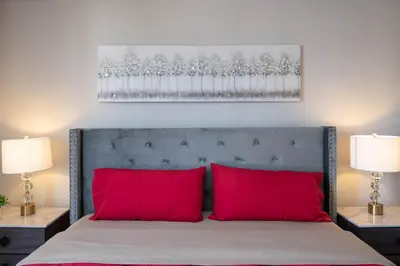 a bed with two red pillows in a bedroom at Chic Hollywood Retreat 2Bed Rooftop Pool with Iconic Views in Los Angeles