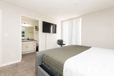 a bedroom with a bed and a bathroom with a sink at Hollywood Luxe 2BR Apartment with Rooftop Pool and Breathtaking Views in Los Angeles