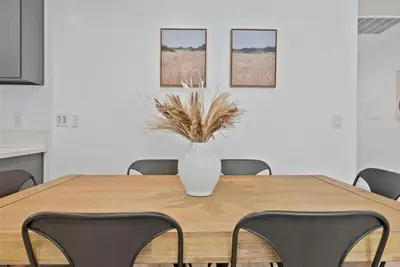 a vase sitting on a wooden table with chairs at South Bay 3 bed Escape! in Harbor City