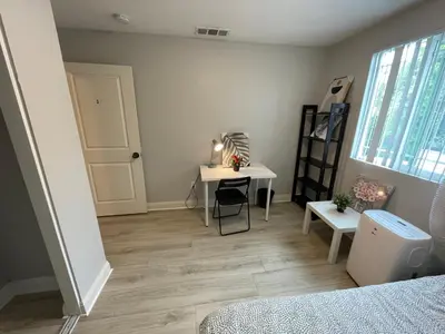 a bedroom with a desk and a table and a window at The Blue Hostel - Near USC, BMO in Los Angeles