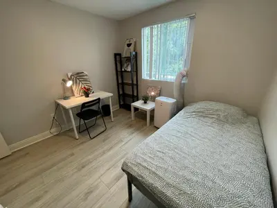 a bedroom with a bed and a desk and a window at The Blue Hostel - Near USC, BMO in Los Angeles