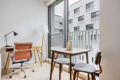 a desk and chairs in a room with a window at Blueground Downtown elevator nr parks LAX-1247 in Los Angeles