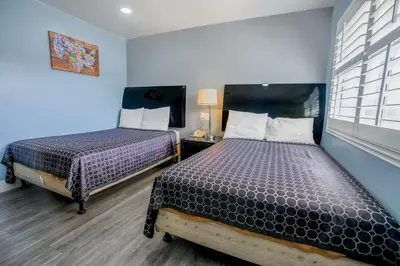 two beds in a room with blue walls at Economy Inn Buttonwillow Bakersfield I-5 in Buttonwillow