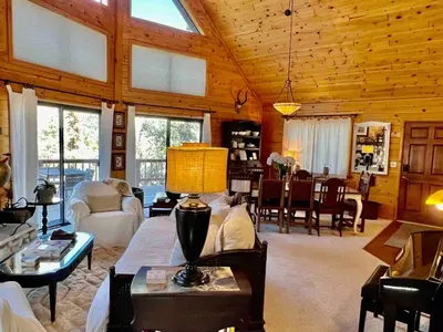 a living room with a couch and a table at ADELAIDE HILL IN PINE MOUNTAIN CLUB BREATHTAKING VIEWS 3Bd 3Bth SPA TUB in Pine Mountain Club