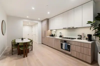a kitchen with white cabinets and a table in it at Luxurious 2-Bedroom Retreat in Santa Monica in Los Angeles