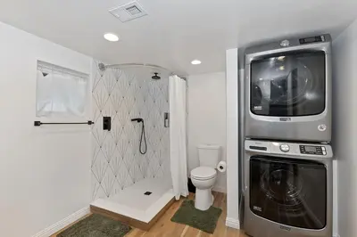 a bathroom with a washer and dryer next to a toilet at Lake Gregory Skyline Ridge in Crestline