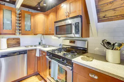 a kitchen with a stove and a microwave at Family-Friendly Lake Arrowhead Cabin with Game Room! in Lake Arrowhead
